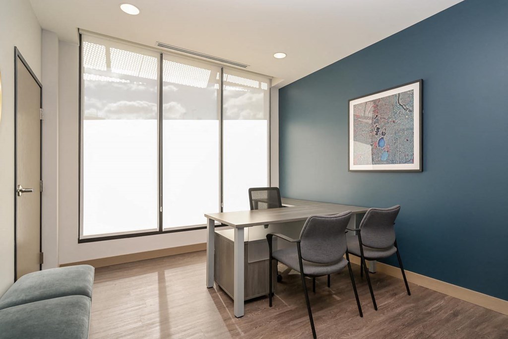 a conference room with a large window and a table with chairs