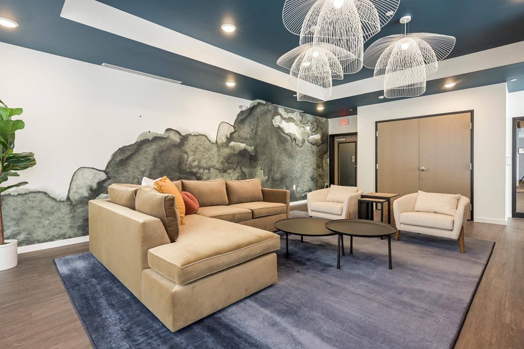 a living room with couches and chairs and a mural on the wall