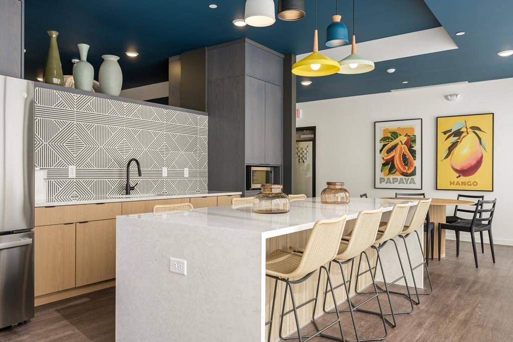 a kitchen with a large counter and chairs