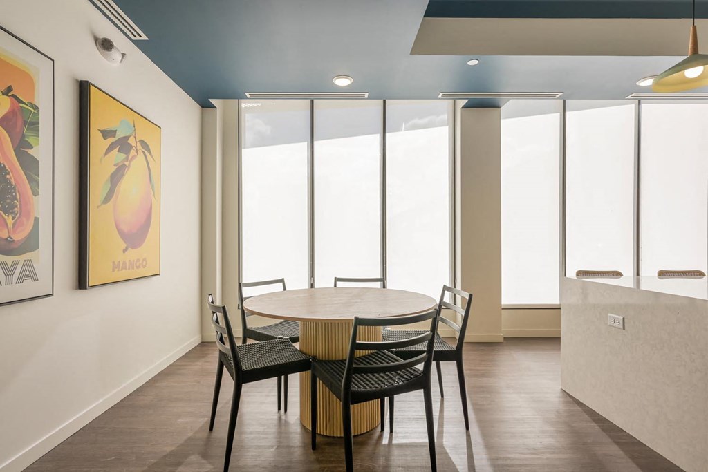 a dining room with a table and chairs and windows