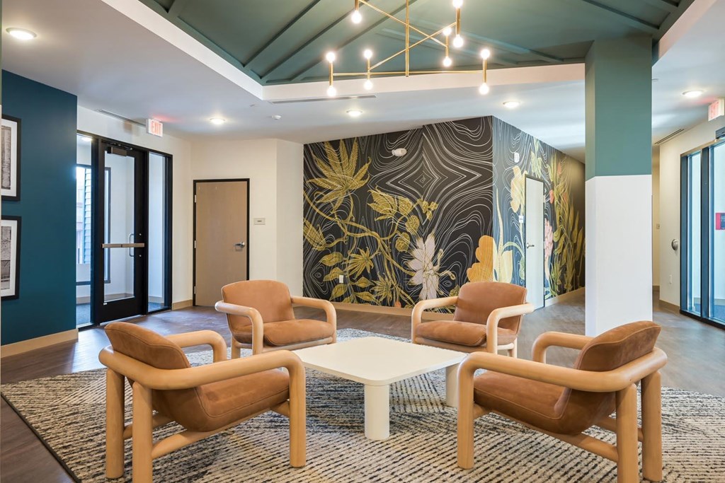 a lobby with chairs and a large mural on the wall