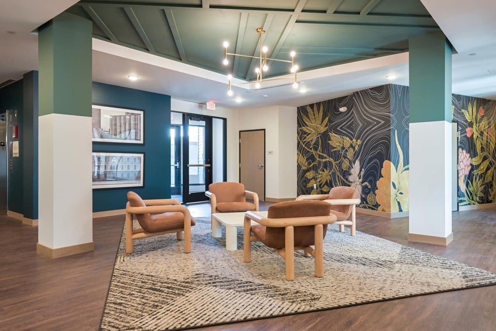 a lounge area with chairs and a mural on the wall