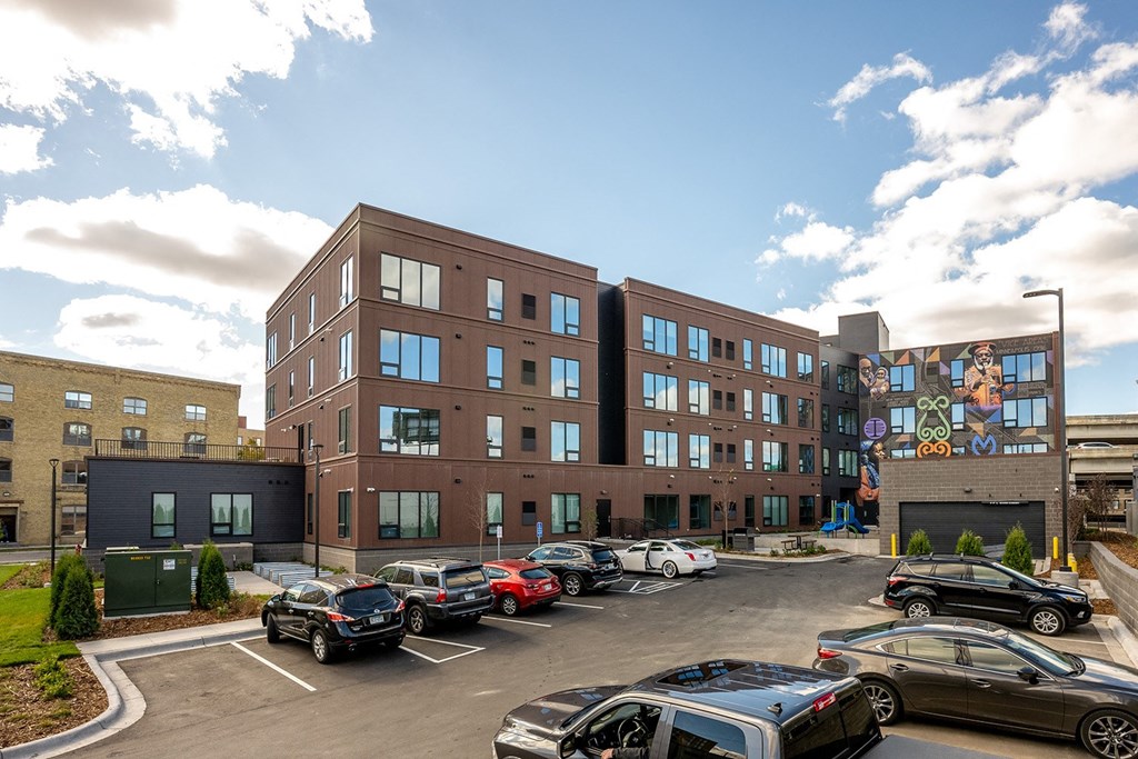 a large building with cars parked in a parking lot