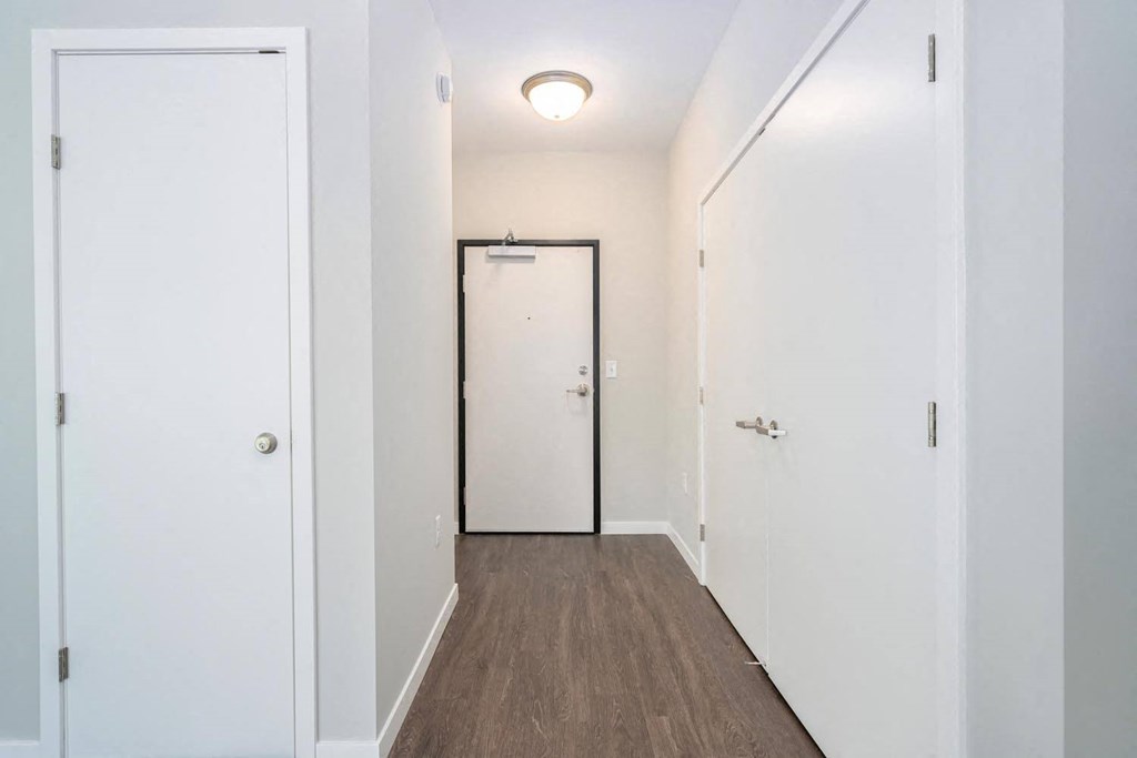 a hallway with white walls and a door to a closet