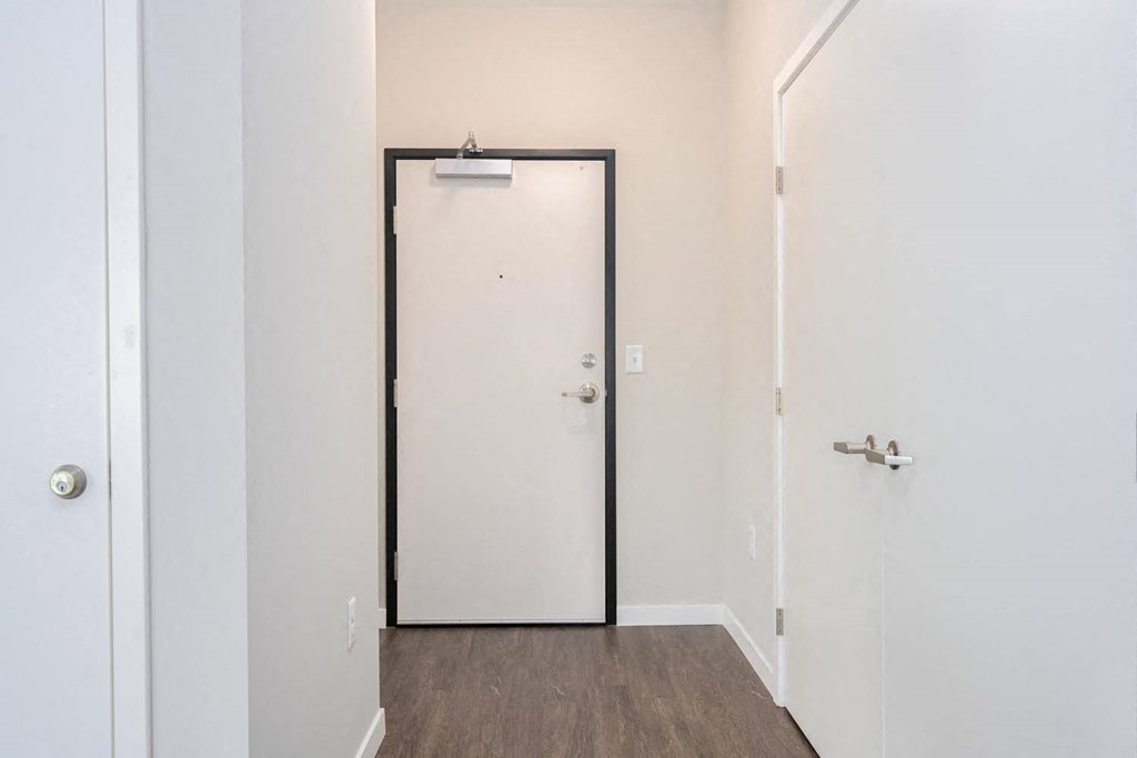a white door with a black frame in a room with white walls