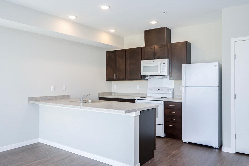 a kitchen with a white counter top and a refrigerator