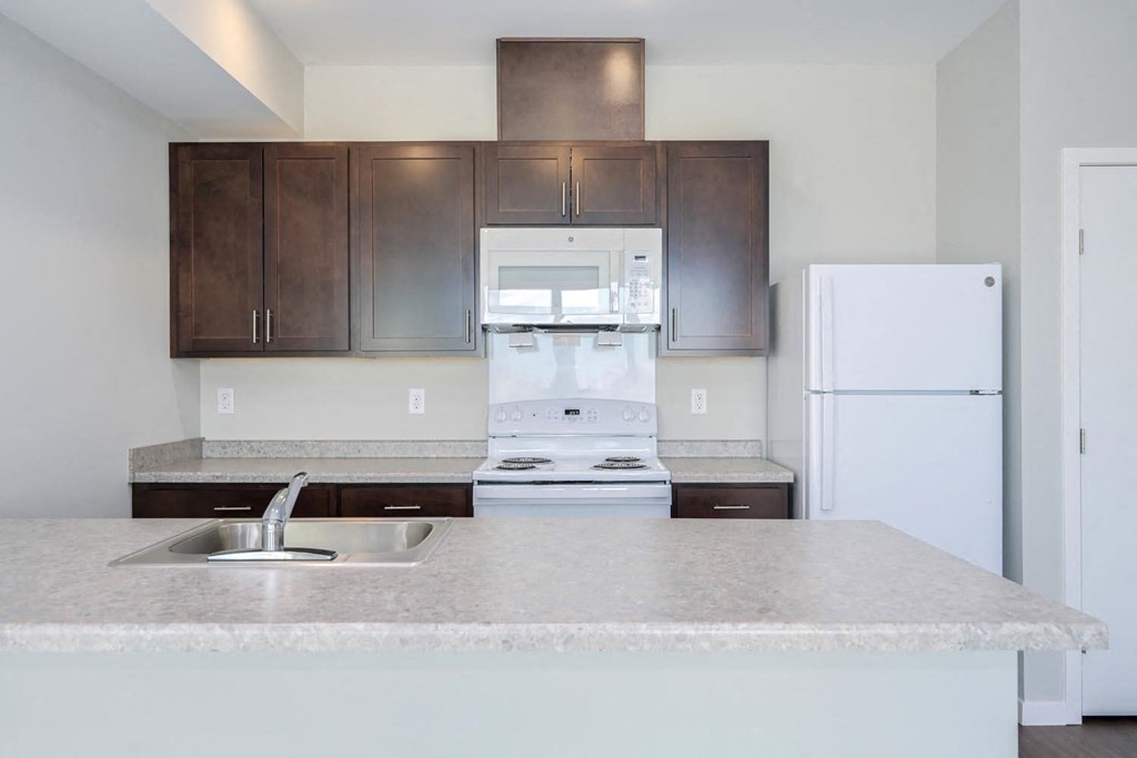 a kitchen with white appliances and a granite counter top