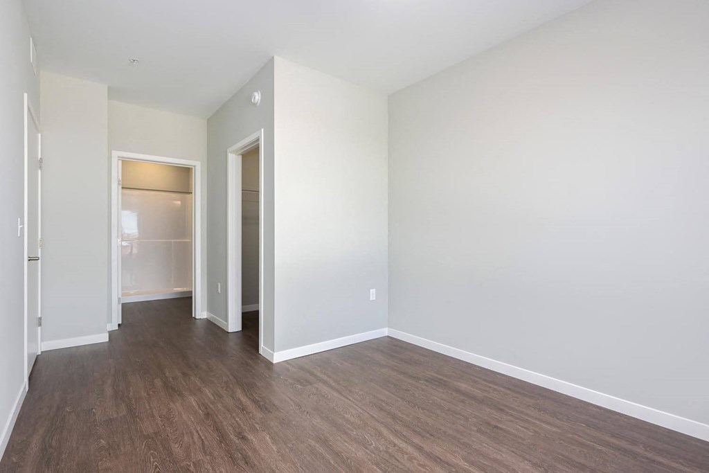 an empty living room with white walls and wood floors