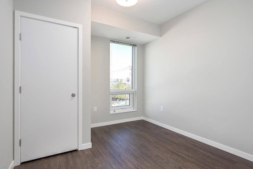 an empty room with a window and a door