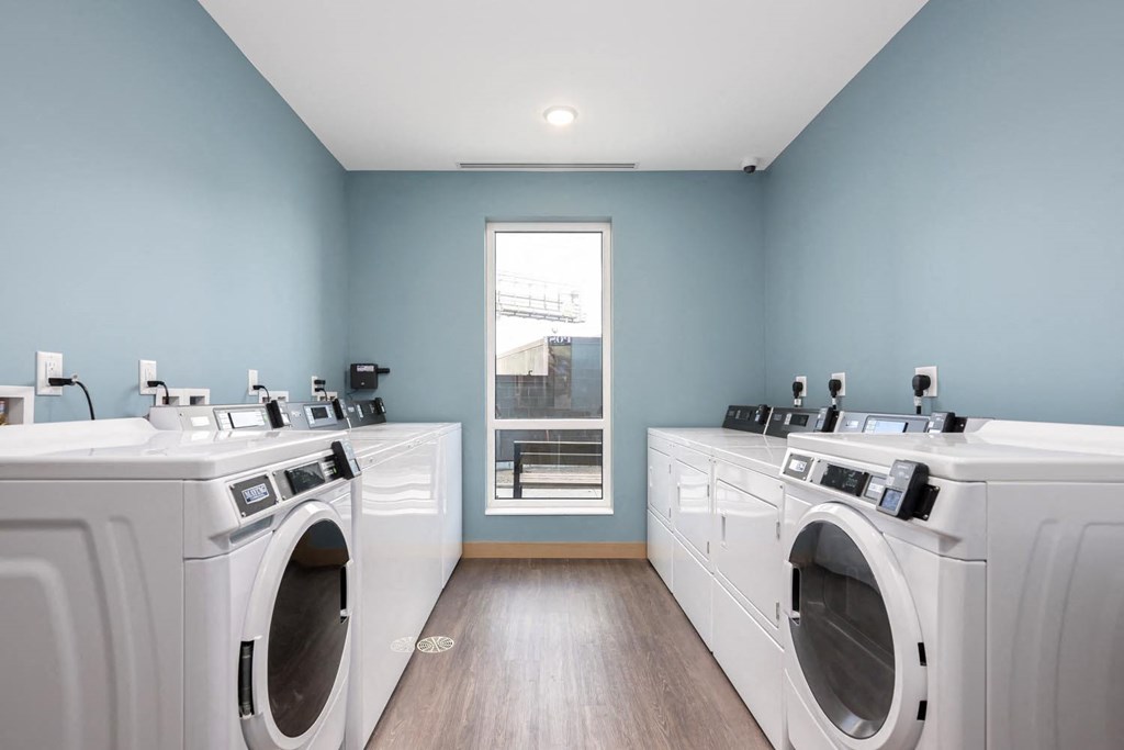 a washer and dryer room with two washing machines and a window