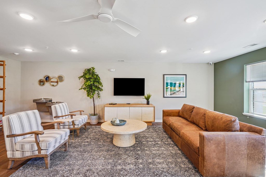 A living room with a striped chair, a brown couch, and a white coffee table.