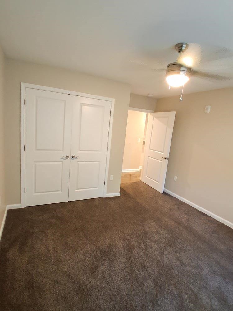 A room with a ceiling fan and two doors.