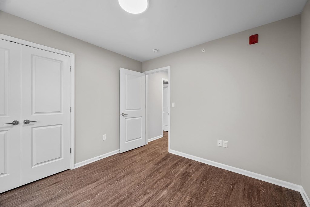 A room with white doors and a wooden floor.