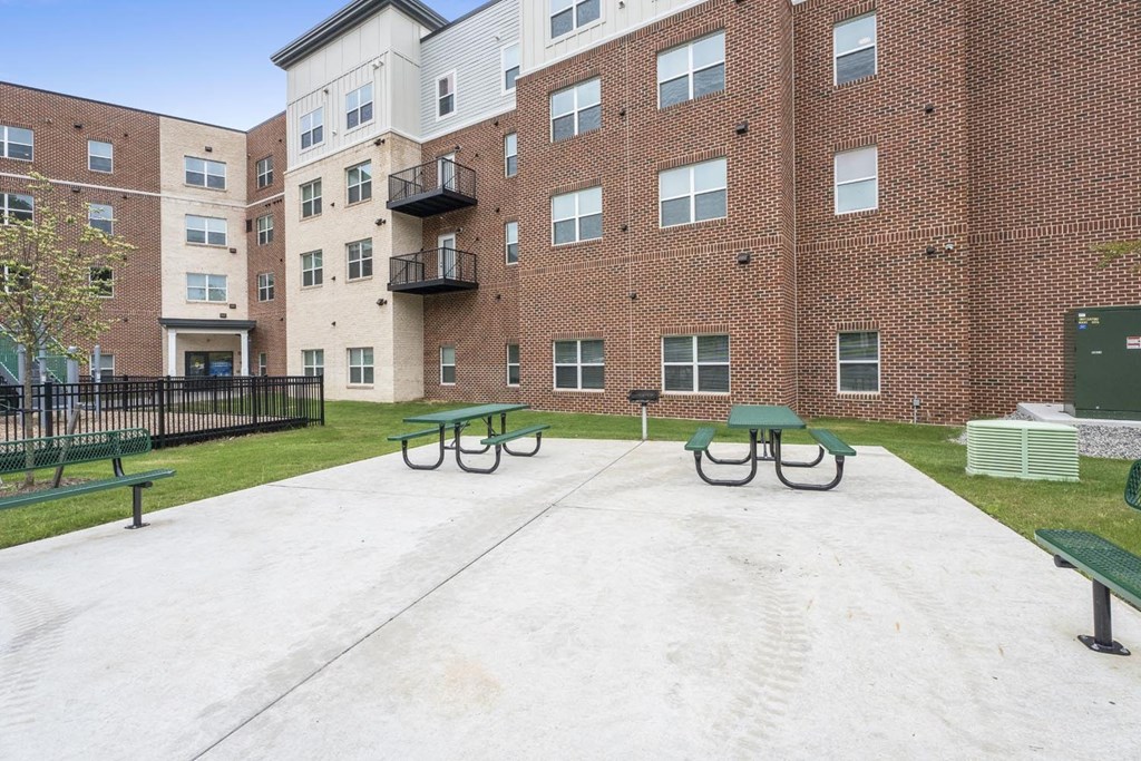 A large brick building with a courtyard in front.