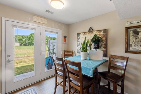 a dining room with a table and chairs and a patio door