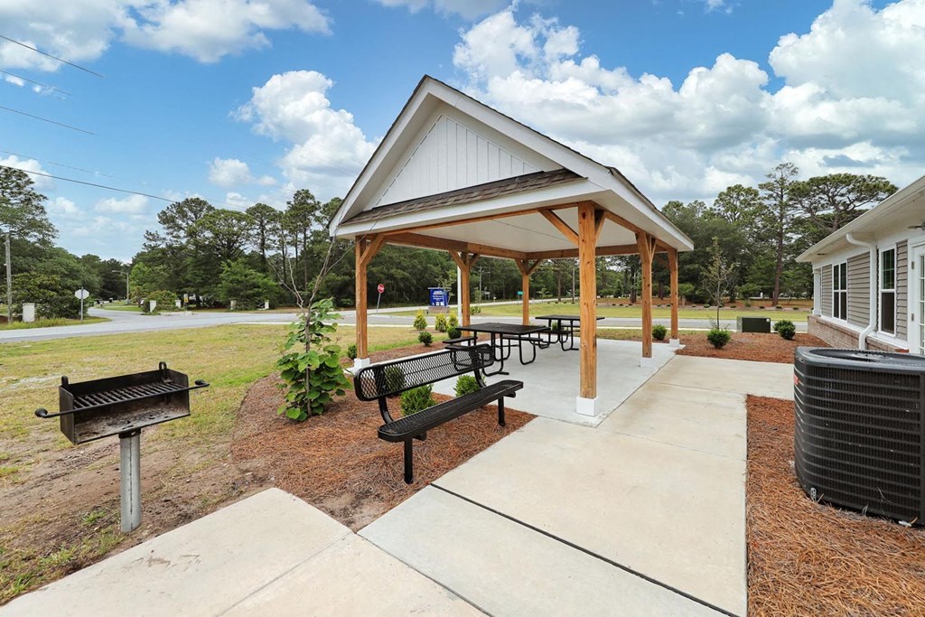 a picnic pavilion with benches and a grill