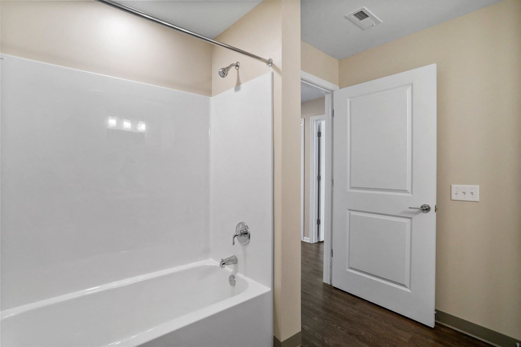 a bathroom with a white bathtub and a white door
