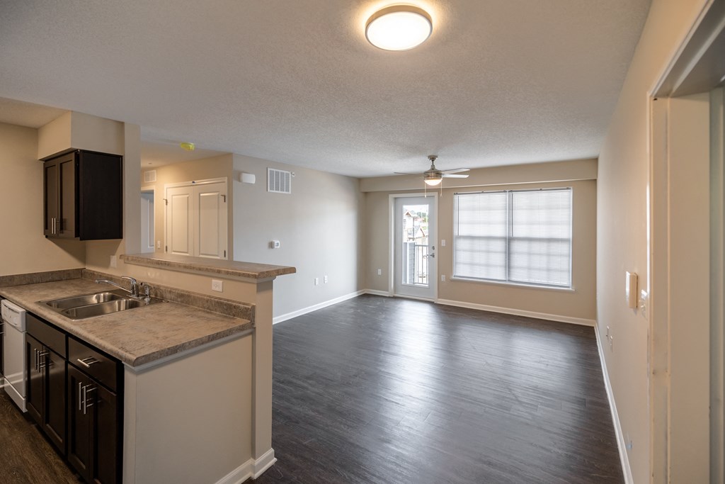 an empty kitchen and living room with a large window