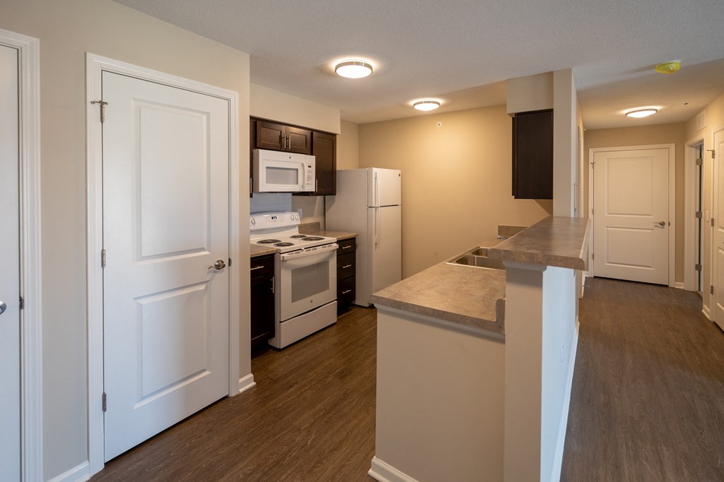 a renovated kitchen with white appliances and a large counter top