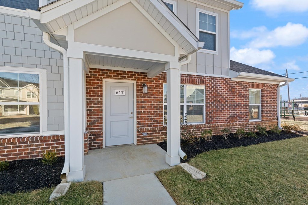 A house with a white door and windows is numbered 617.