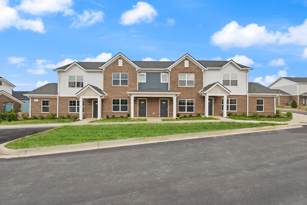 A large, multi-story residential building with a driveway in front.