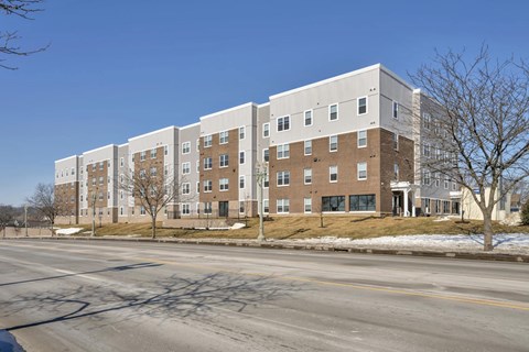 A large multi-story building with a flat roof and a parking lot in front.