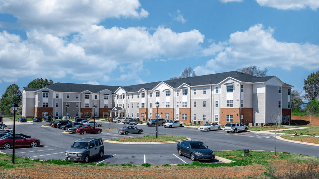 a parking lot with cars in front of an apartment building
