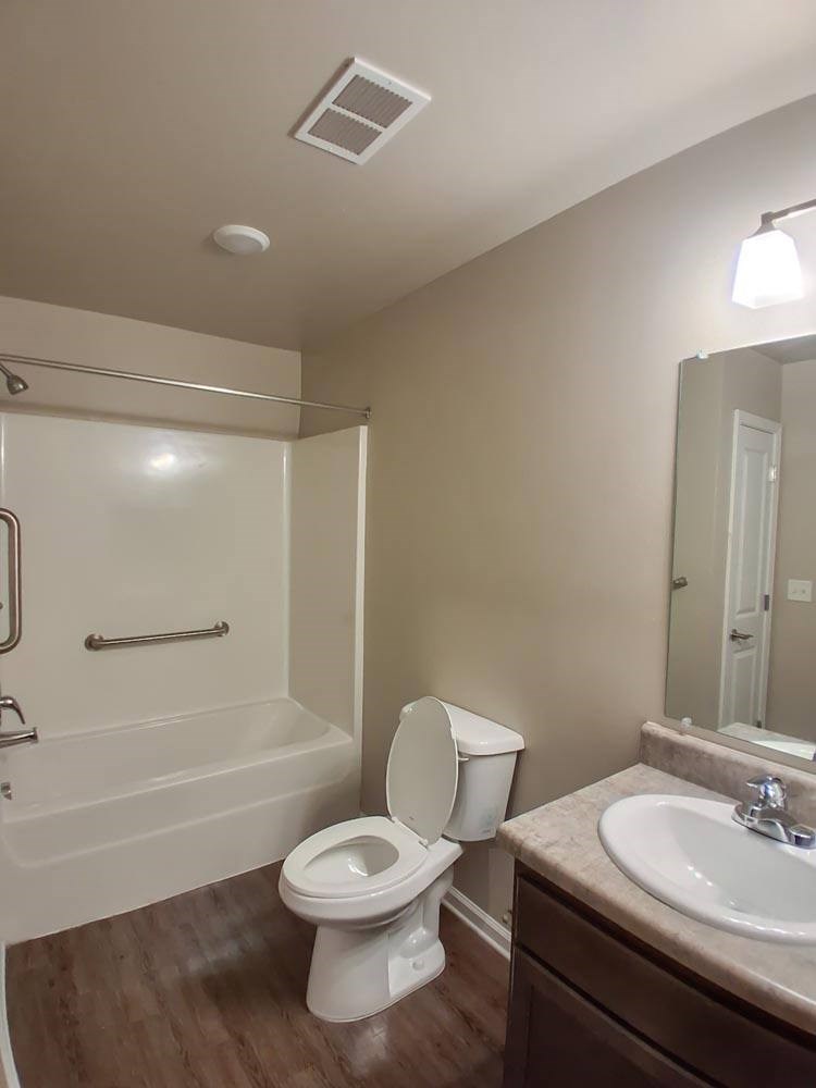 A white toilet sits next to a sink in a bathroom.