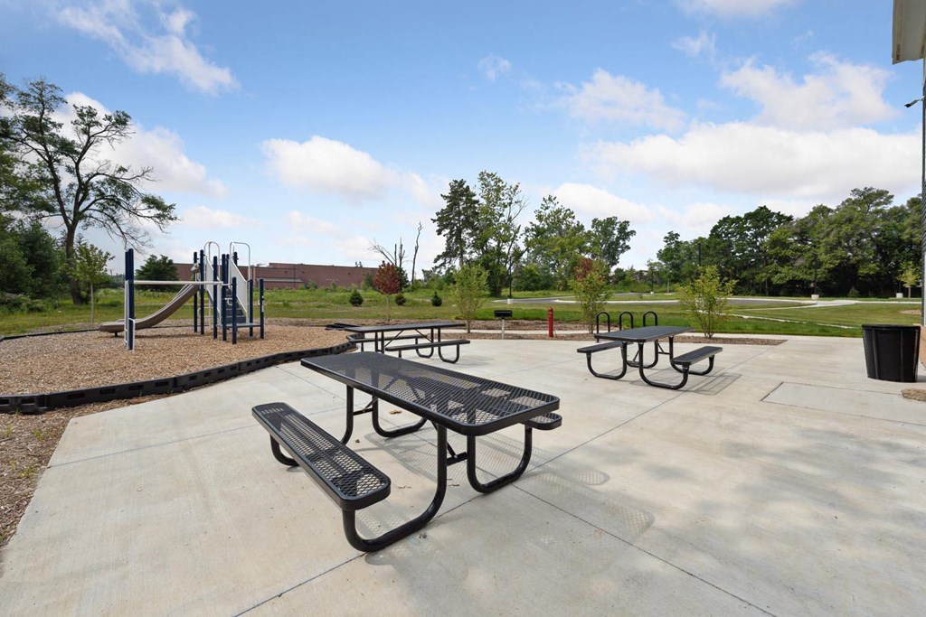 picnic tables and playground equipment at the whispering winds apartments in pearland, tx