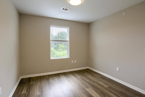 A room with a window and wooden flooring.