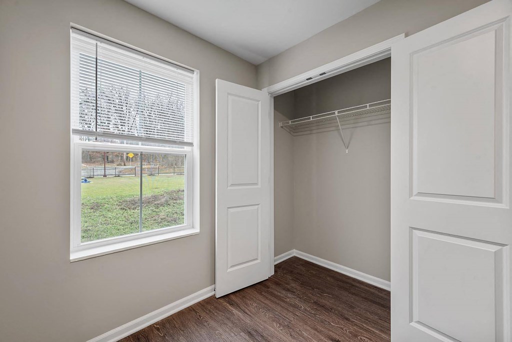 A room with a window and a closet.