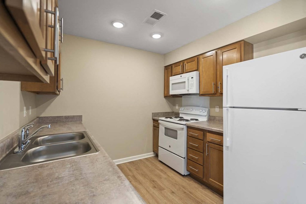 a kitchen with a stove refrigerator and sink