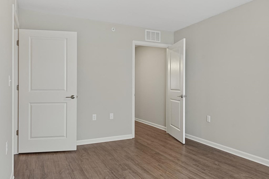 a bedroom with two doors and a wood floor