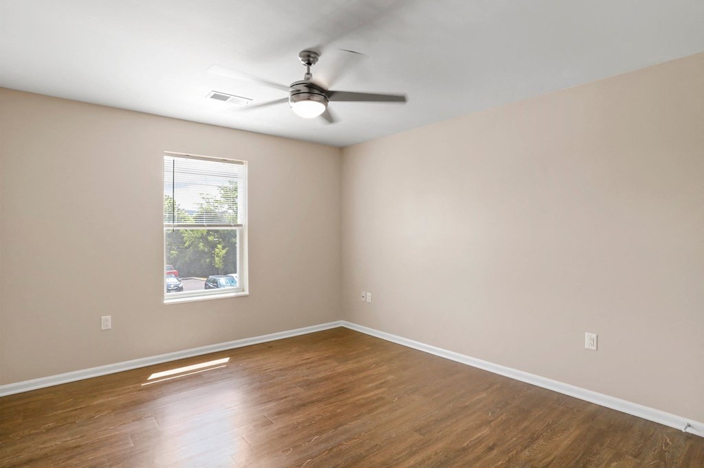 an empty room with a ceiling fan and a window