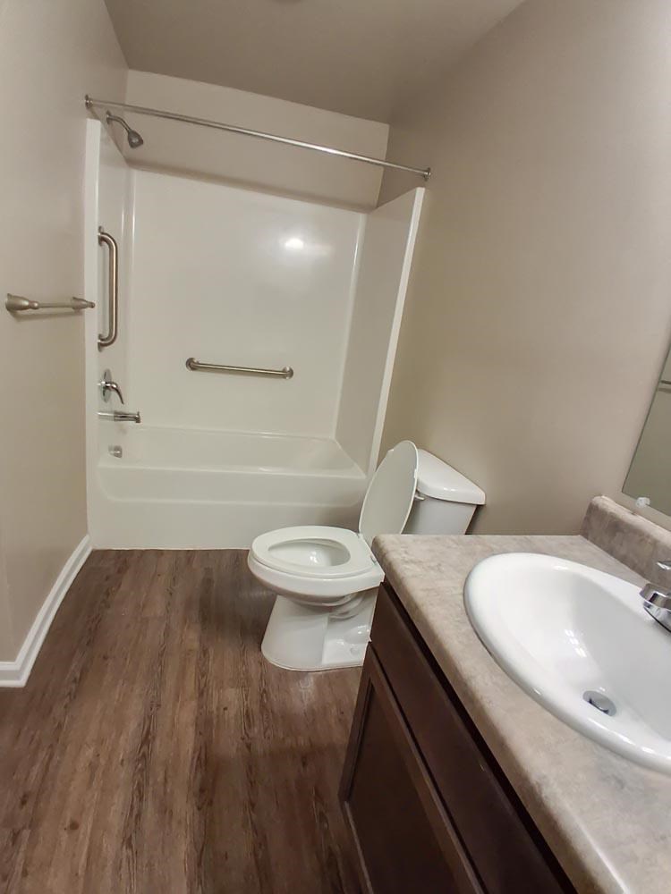 A white toilet sits in a bathroom next to a sink.