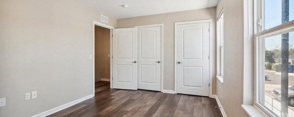 a bedroom with two doors and a window