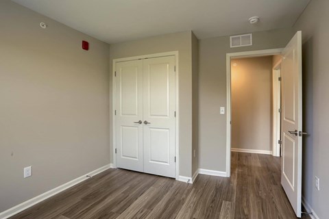 A room with a white door and a wooden floor.