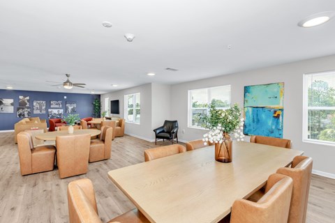 A conference room with a long table surrounded by chairs.