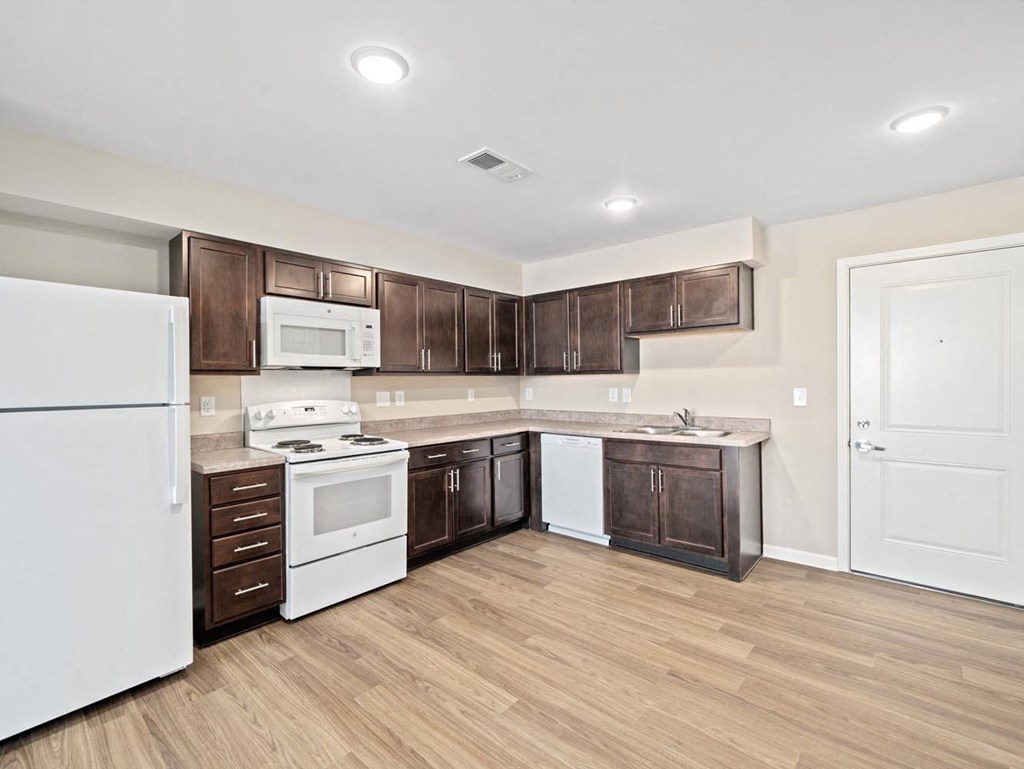 a kitchen with white appliances and brown cabinets