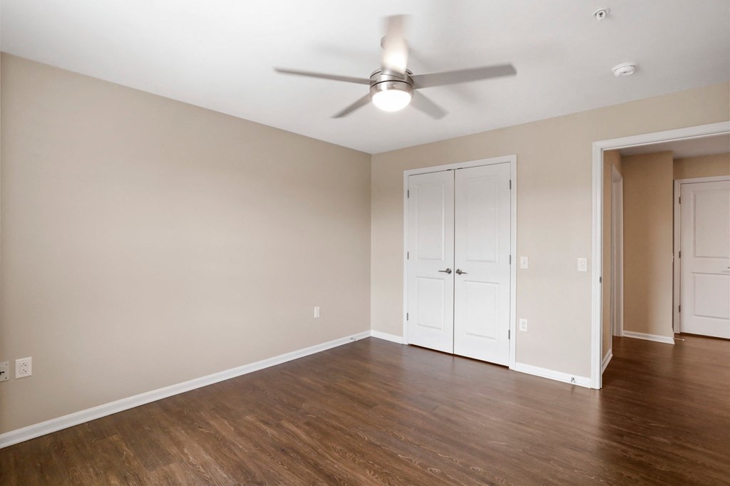 a bedroom with hardwood floors and a ceiling fan