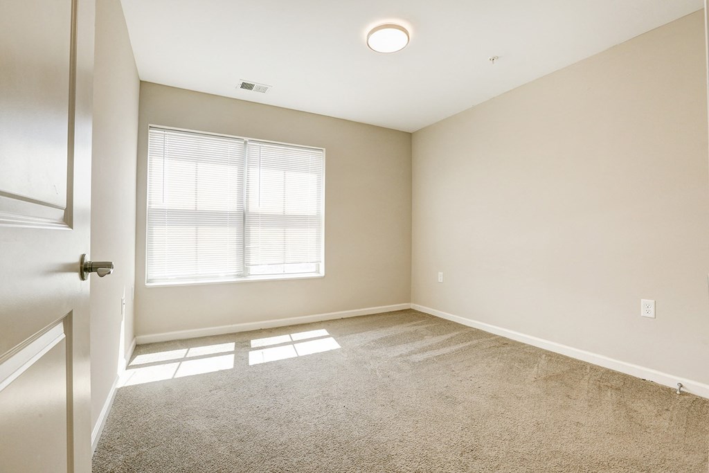 an empty room with a window and a door