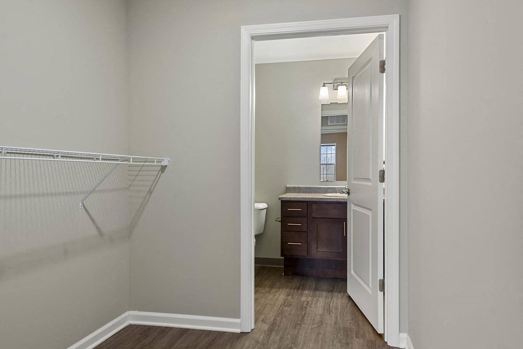 a room with a door open to a bathroom with a sink and a toilet