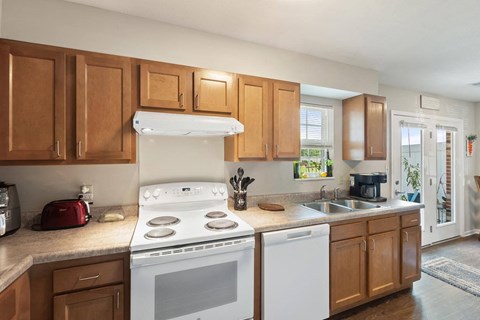 a kitchen with white appliances and wooden cabinets