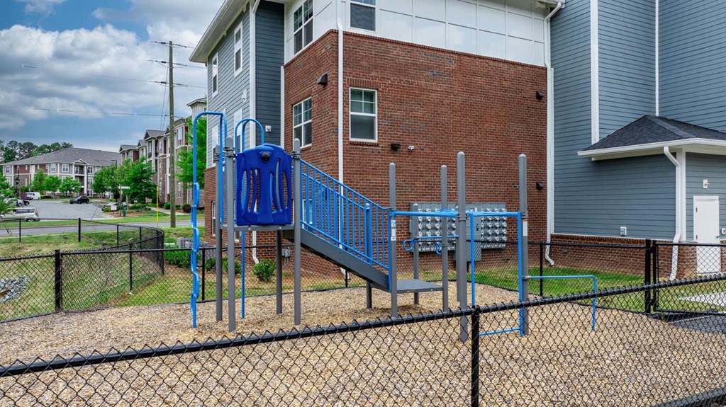 a playground in front of a building with a blue slide