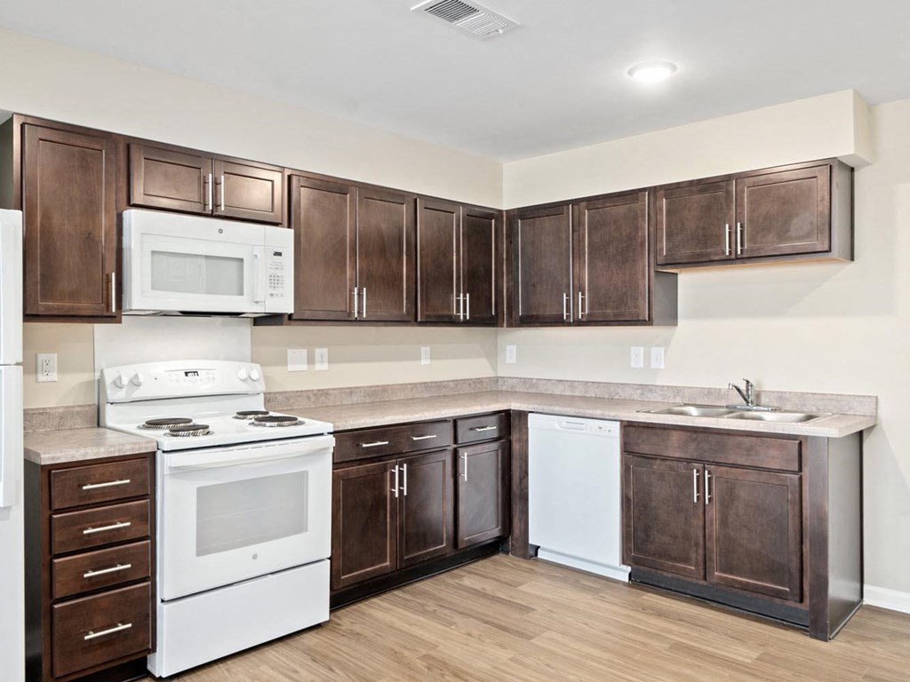 a kitchen with white appliances and brown cabinets