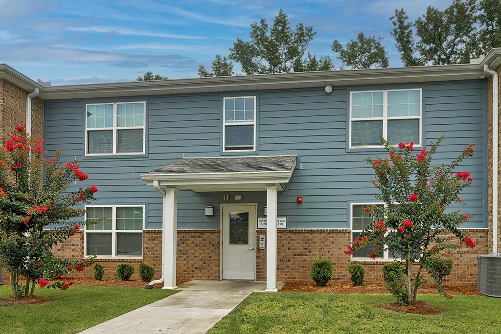 a blue house with a sidewalk in front of it
