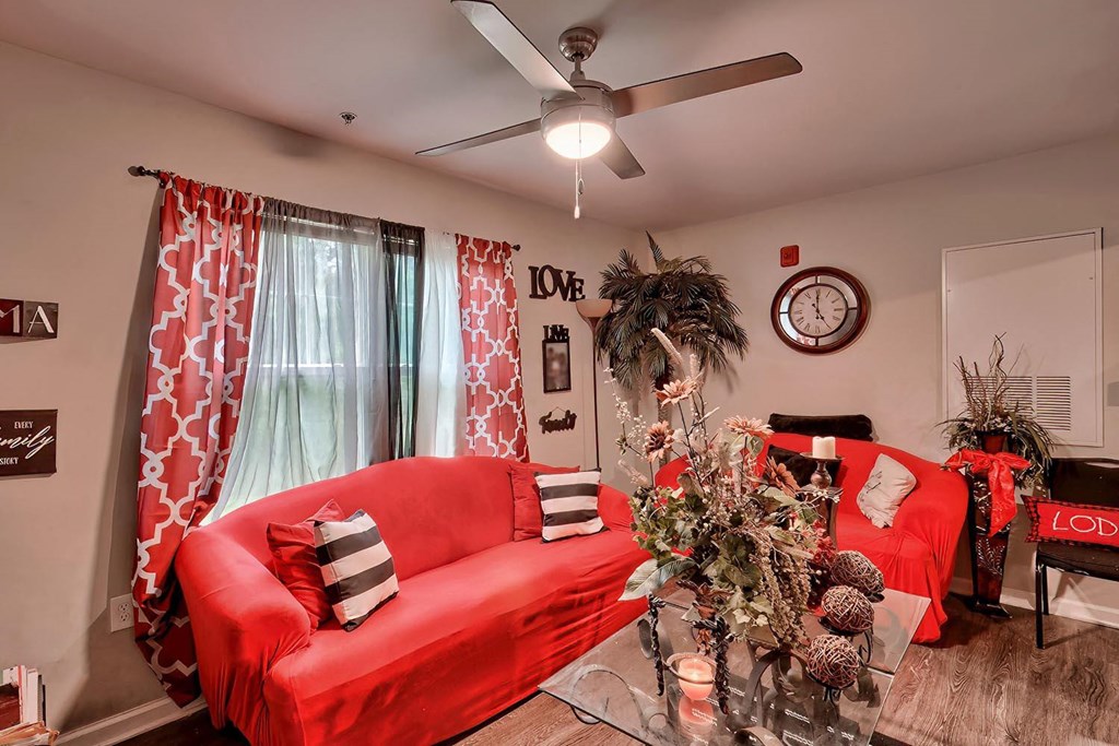 a living room with a red couch and a christmas tree