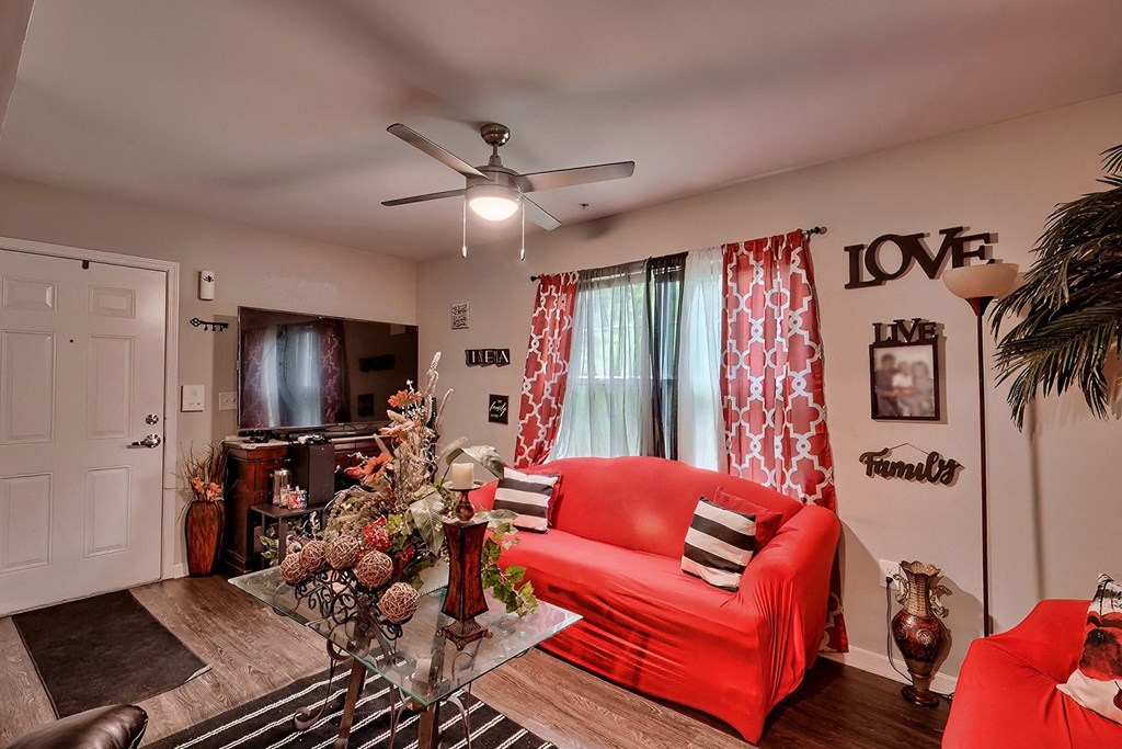 a living room with a red couch and a christmas tree