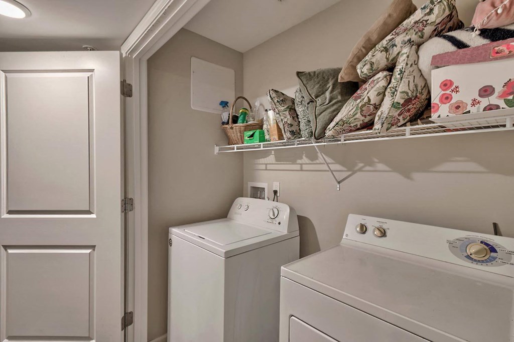 a white washer and dryer in a small laundry room