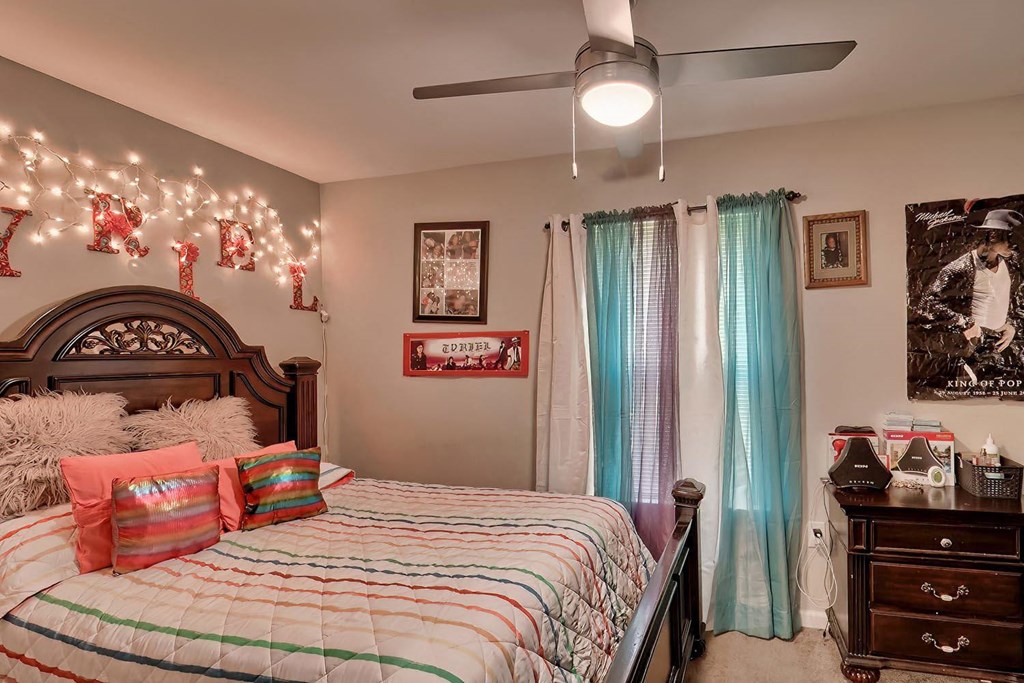 a bedroom with a bed and a ceiling fan